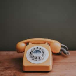 Telefono vintage arancione appoggiato su una scrivania