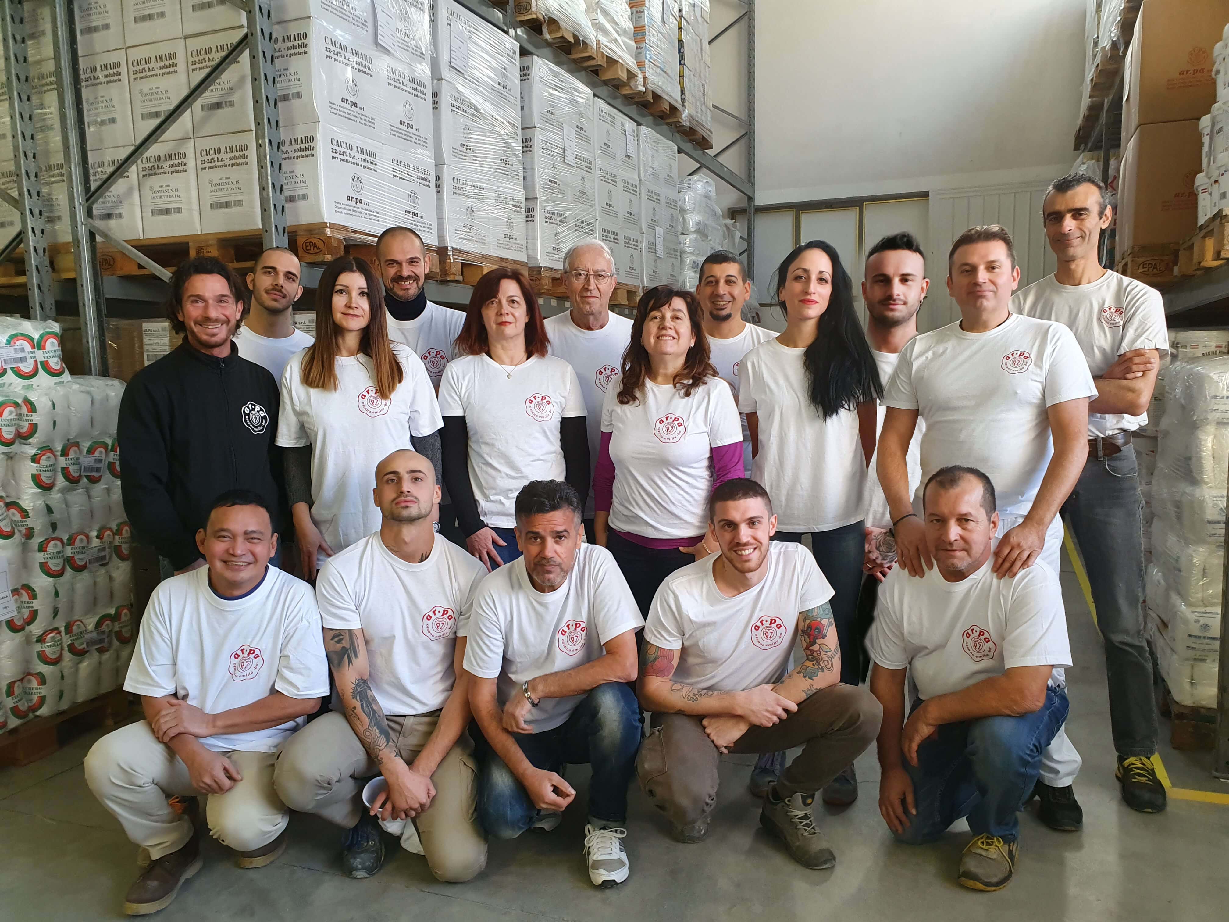 Foto di gruppo del team di Ar.pa Lieviti riunito all’interno del magazzino aziendale, tra gli imballaggi dei prodotti