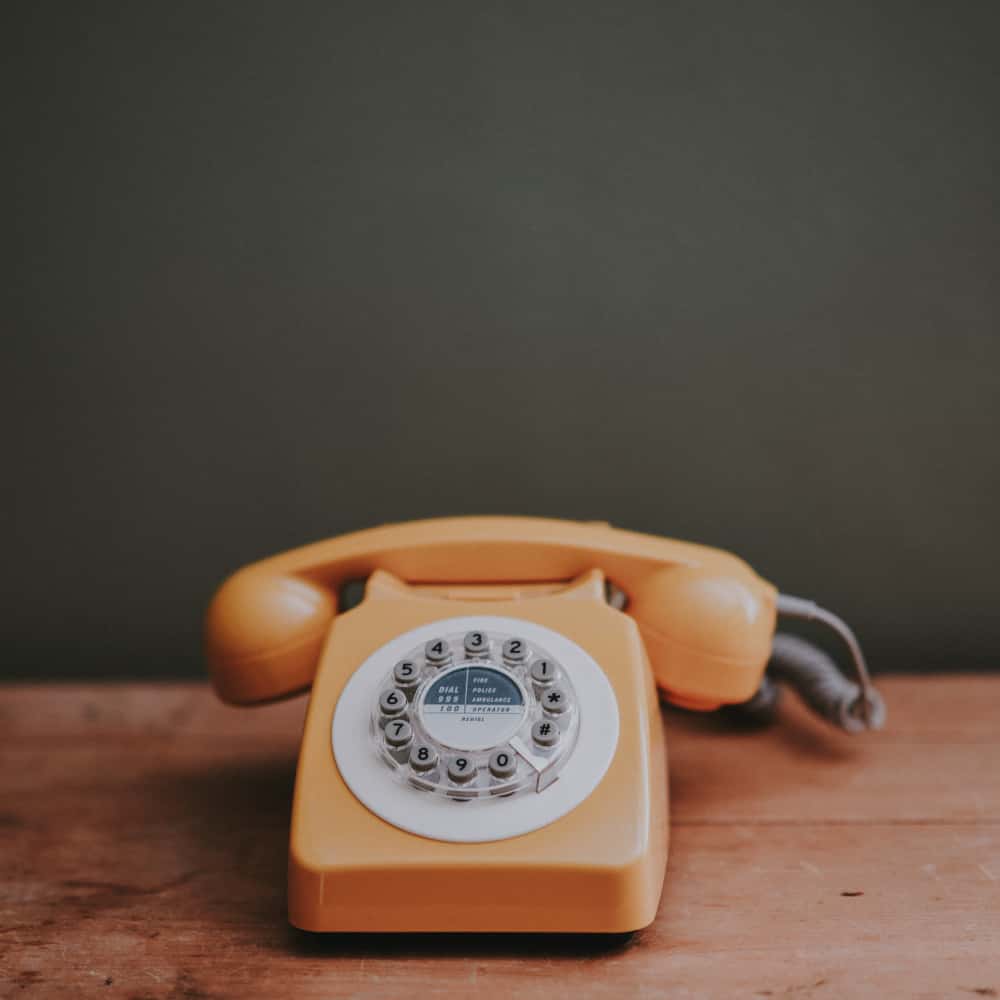Telefono vintage arancione appoggiato su una scrivania